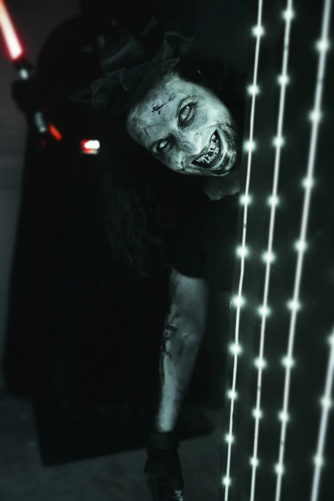 A grinning character peers around a doorway beside vertical lights.